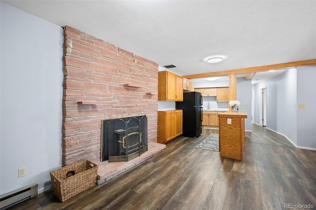 kitchen featuring dark wood-style flooring, baseboard heating, light countertops, and freestanding refrigerator