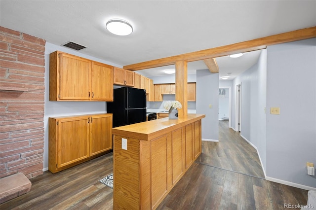 kitchen with visible vents, dark wood-style floors, freestanding refrigerator, light countertops, and beam ceiling