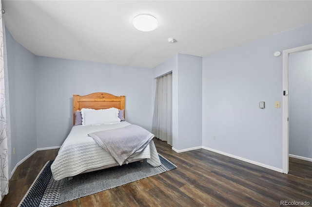 bedroom featuring a closet, baseboards, and wood finished floors