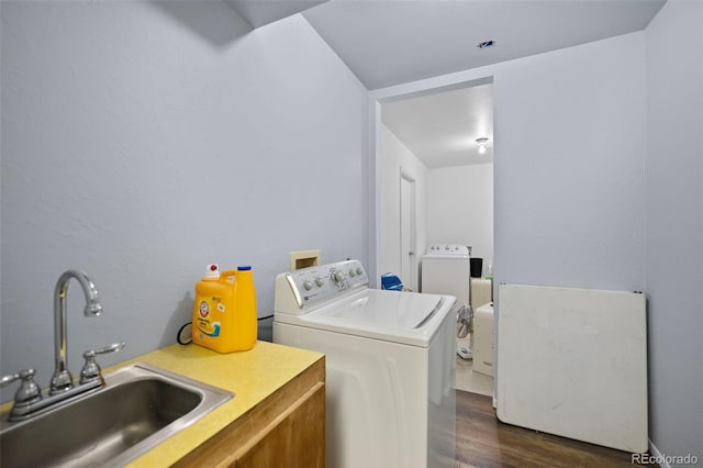 laundry room featuring dark wood-style floors, laundry area, a sink, and separate washer and dryer