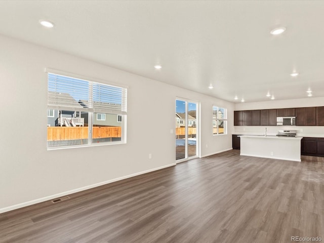 unfurnished living room featuring hardwood / wood-style flooring and sink