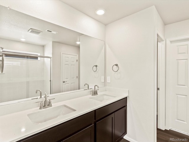 bathroom with vanity, wood-type flooring, and a shower with door