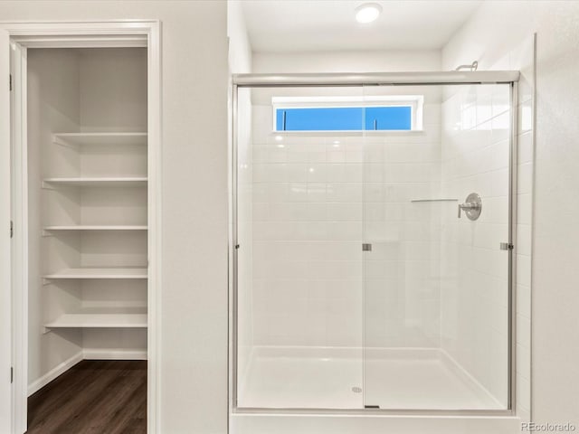 bathroom with hardwood / wood-style flooring and walk in shower