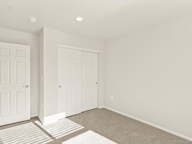 unfurnished bedroom featuring a closet and light colored carpet