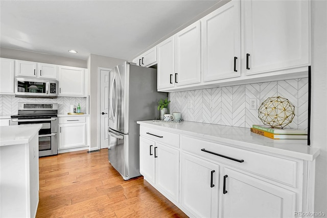 10115 Foxridge Ct, Highlands Ranch, CO 80126 - kitchen featuring appliances with stainless steel finishes, backsplash, light countertops, white cabinets, and recessed lighting