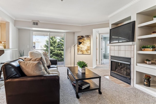 living room with light colored carpet, built in features, crown molding, and a tiled fireplace