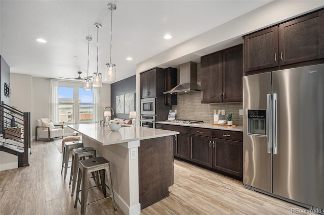 9072 E 47th Ave, Denver, CO 80238 - kitchen with stainless steel appliances, wall chimney range hood, a sink, light countertops, and a breakfast bar area