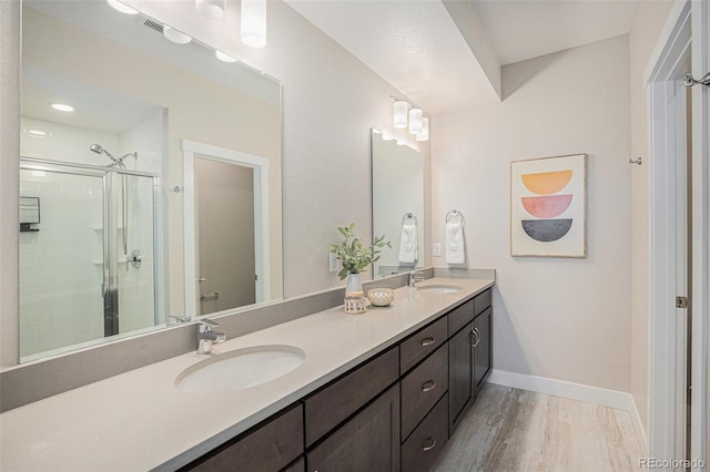 9072 E 47th Ave, Denver, CO 80238 - bathroom featuring a shower stall, wood finished floors, double vanity, baseboards, and toilet