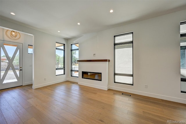 414 E Arkansas St, Buena Vista, CO 81211 - unfurnished living room with light wood finished floors, a glass covered fireplace, and recessed lighting