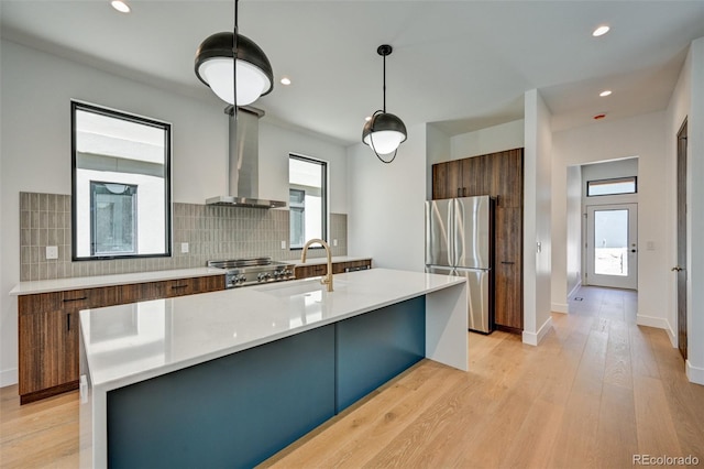 414 E Arkansas St, Buena Vista, CO 81211 - kitchen with freestanding refrigerator, modern cabinets, wall chimney exhaust hood, decorative backsplash, and light countertops