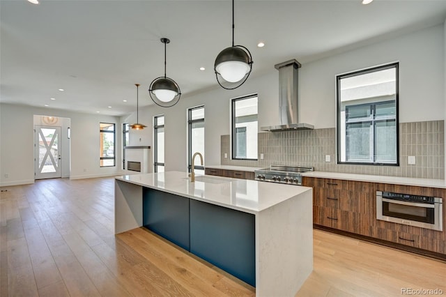 414 E Arkansas St, Buena Vista, CO 81211 - kitchen with modern cabinets, exhaust hood, light countertops, brown cabinets, and light wood finished floors