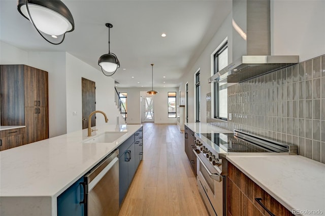 414 E Arkansas St, Buena Vista, CO 81211 - kitchen featuring stainless steel appliances, wall chimney exhaust hood, light wood-type flooring, recessed lighting, and decorative light fixtures