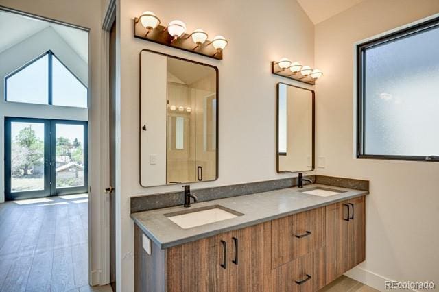 414 E Arkansas St, Buena Vista, CO 81211 - bathroom featuring double vanity, vaulted ceiling, and wood finished floors