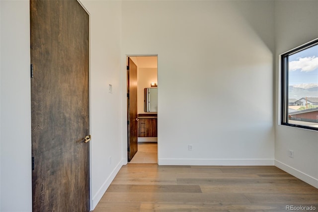 414 E Arkansas St, Buena Vista, CO 81211 - unfurnished bedroom with light wood-style flooring, ensuite bath, and a high ceiling