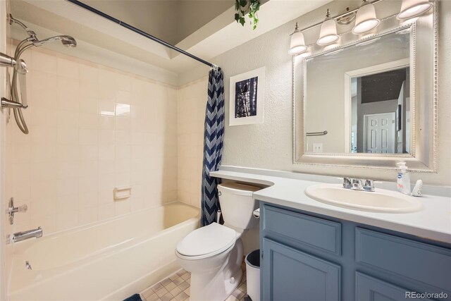 full bathroom with vanity, toilet, a textured wall, and shower / tub combo with curtain