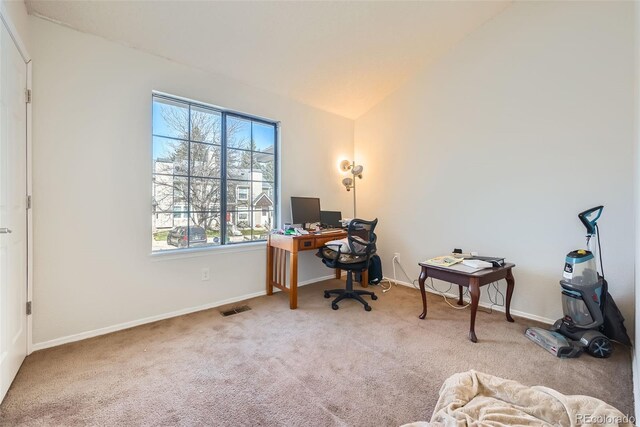 carpeted home office featuring baseboards, visible vents, and lofted ceiling
