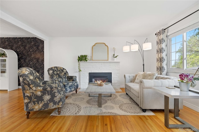 living area featuring wood finished floors and a brick fireplace