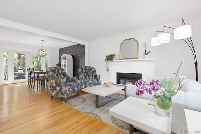 living area with wood finished floors, a fireplace, and a chandelier