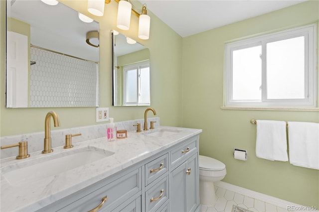 full bathroom featuring healthy amount of natural light, toilet, tile patterned flooring, and double vanity