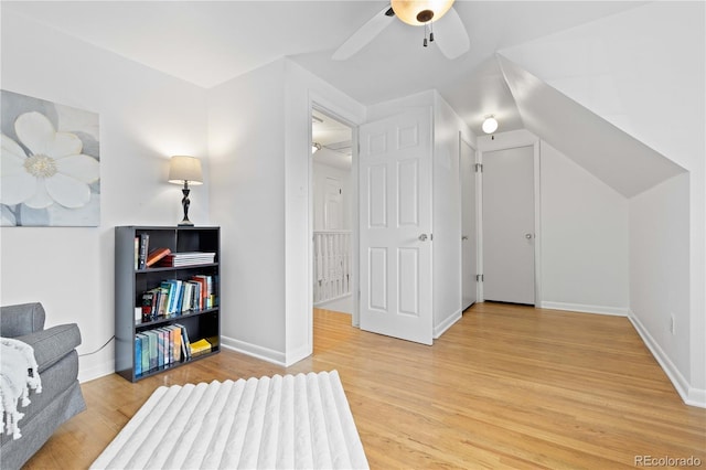 sitting room featuring a ceiling fan, light wood-type flooring, and baseboards