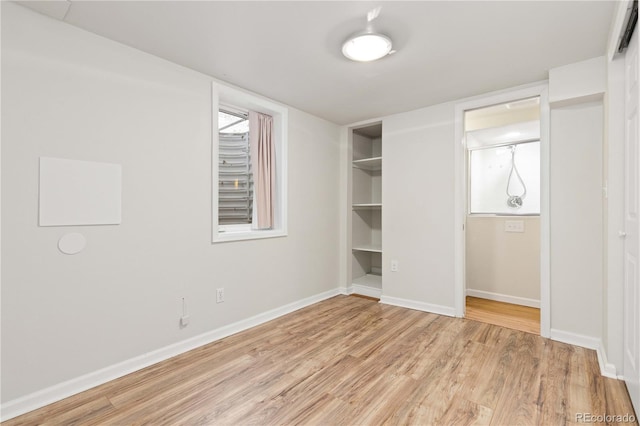 unfurnished bedroom with light wood finished floors, baseboards, and a closet