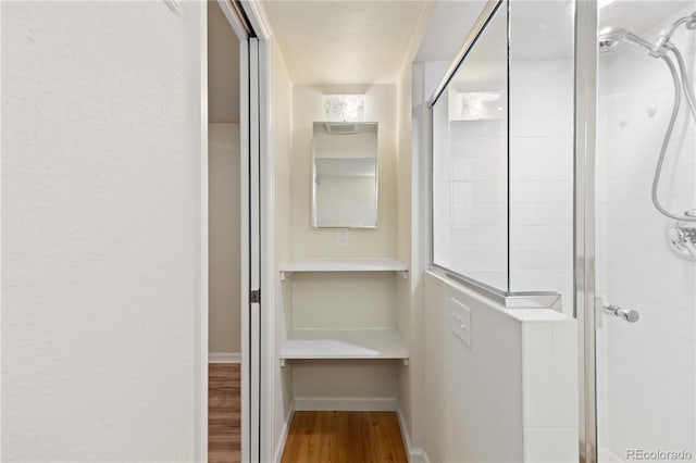 corridor featuring wood finished floors and baseboards