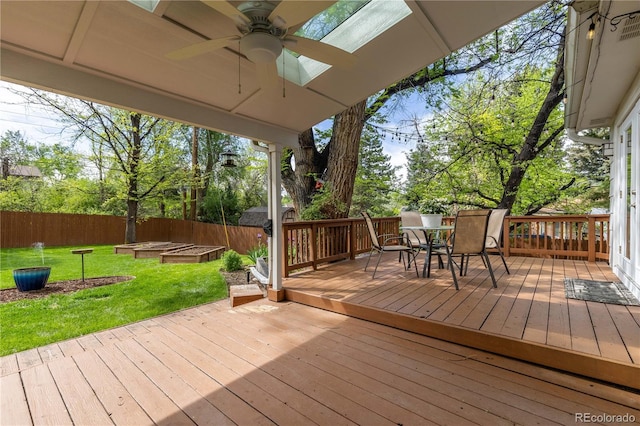 deck with a ceiling fan, outdoor dining space, and a vegetable garden