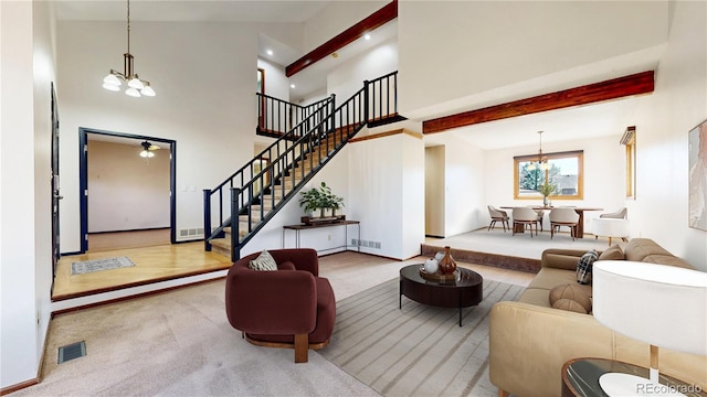 living room with stairs, visible vents, carpet flooring, and an inviting chandelier