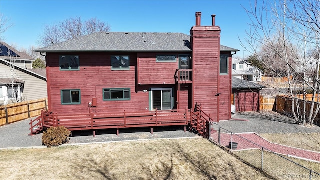 rear view of property featuring a fenced backyard, a lawn, a chimney, and roof with shingles