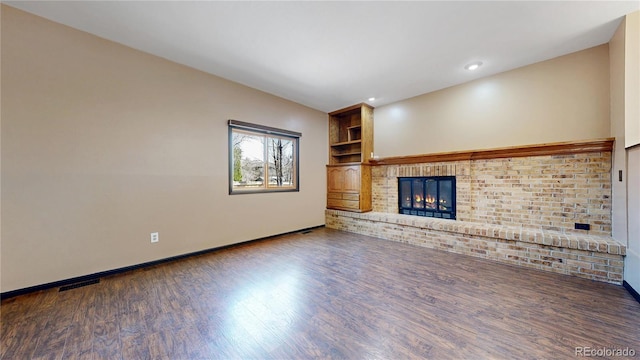 unfurnished living room with recessed lighting, visible vents, a brick fireplace, wood finished floors, and baseboards