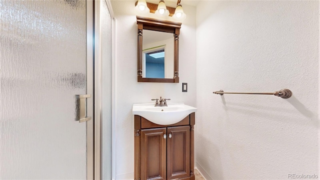 bathroom with a shower stall and vanity