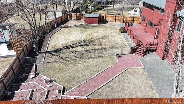 exterior space with an outbuilding, a fenced backyard, and stairs