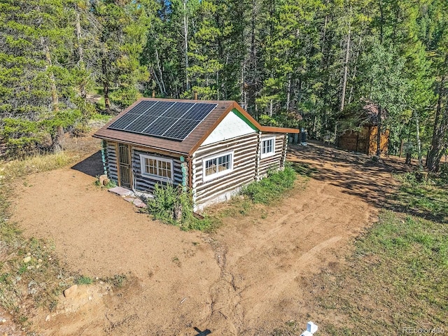view of outdoor structure featuring a forest view and solar panels