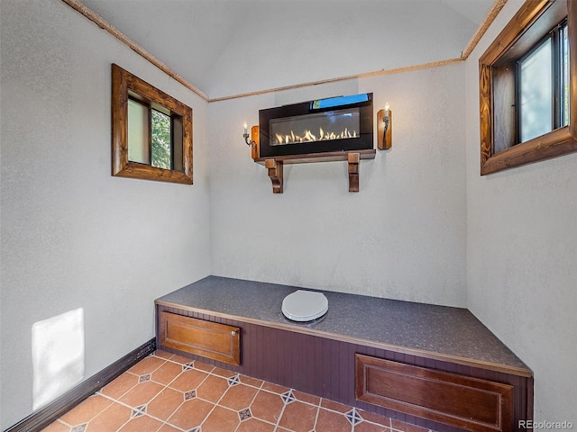 interior space with lofted ceiling and tile patterned flooring