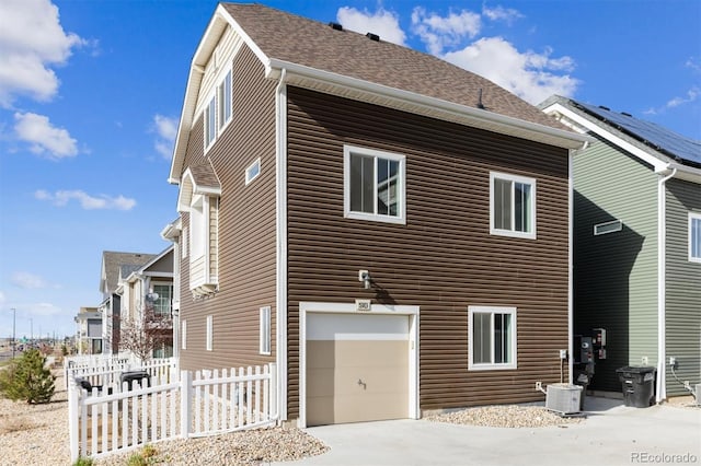 5383 Andes St, Denver, CO 80249 - view of side of home featuring a garage, concrete driveway, and roof with shingles