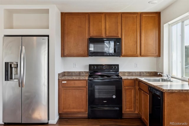 5383 Andes St, Denver, CO 80249 - kitchen featuring black appliances, dark wood-style flooring, brown cabinetry, and plenty of natural light