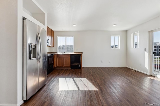 5383 Andes St, Denver, CO 80249 - kitchen featuring black appliances, dark wood-style floors, brown cabinetry, and recessed lighting