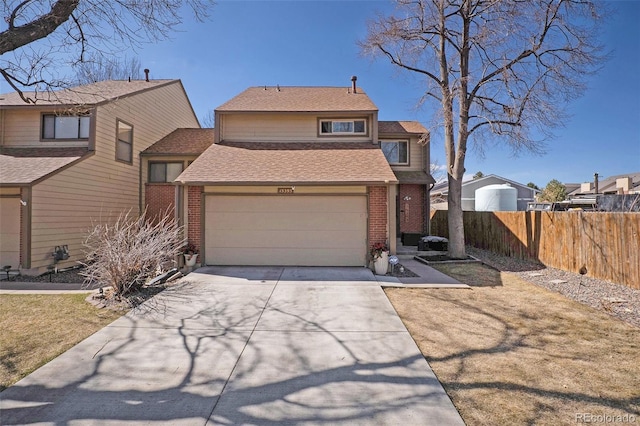 traditional-style house featuring brick siding, a shingled roof, fence, a garage, and driveway