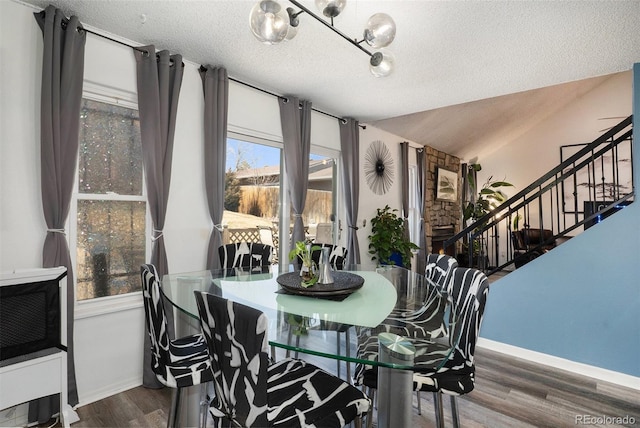 dining space with stairs, wood finished floors, baseboards, and a textured ceiling