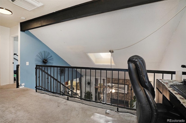 carpeted home office with lofted ceiling with skylight and visible vents