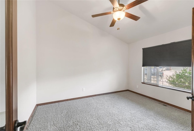 carpeted empty room featuring vaulted ceiling, a ceiling fan, and baseboards