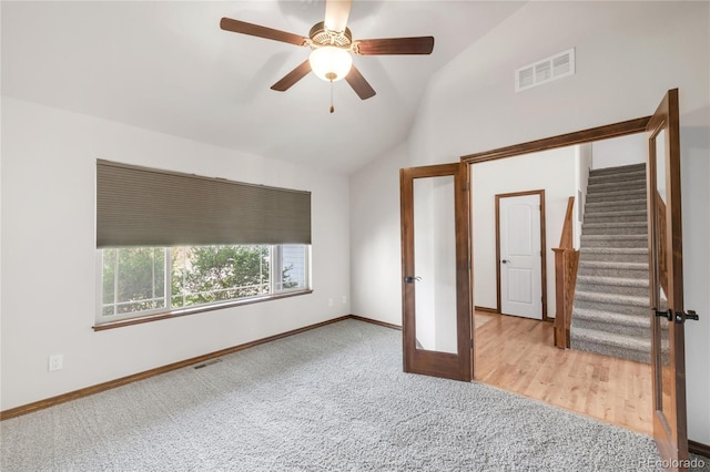 unfurnished bedroom with carpet, vaulted ceiling, baseboards, and a ceiling fan