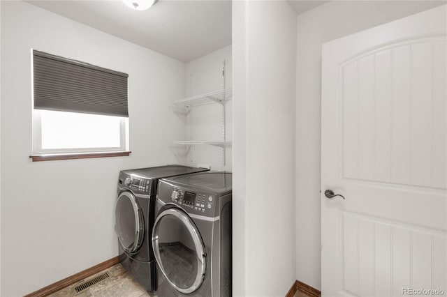 laundry area with separate washer and dryer and baseboards