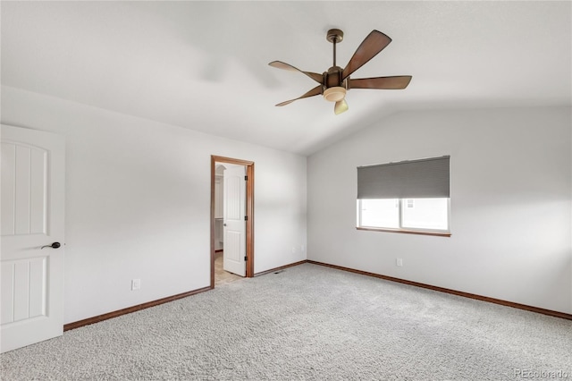 spare room with ceiling fan, vaulted ceiling, carpet floors, and baseboards