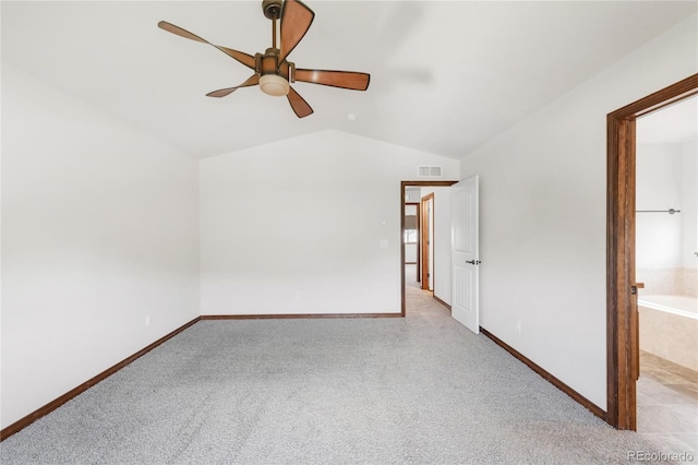 unfurnished bedroom with vaulted ceiling, carpet, baseboards, ceiling fan, and ensuite bath