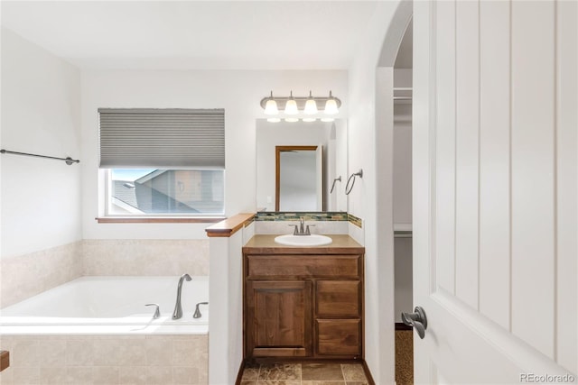 full bath with a bath, a walk in closet, and vanity