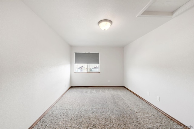 carpeted spare room featuring baseboards