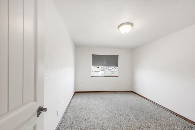 spare room with carpet and baseboards