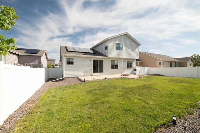 rear view of house with a patio area and solar panels