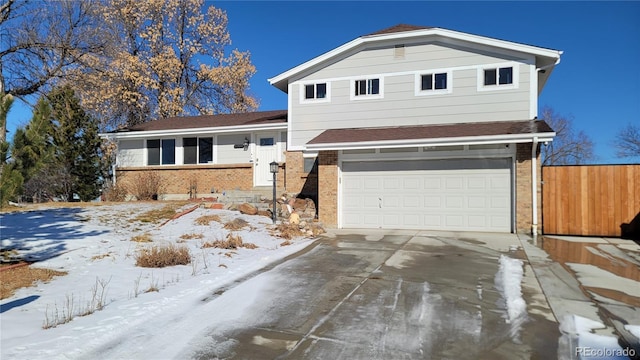 view of front of property with driveway, an attached garage, fence, and brick siding